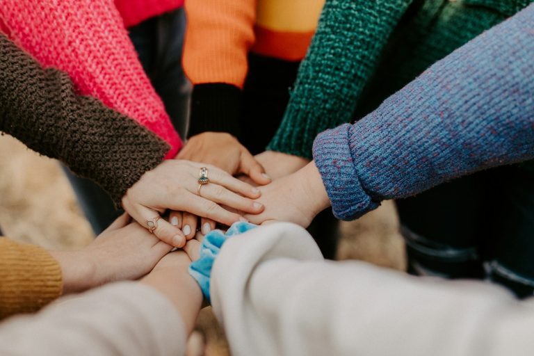 People stacking their hands together, illustrating charitable-sector participation