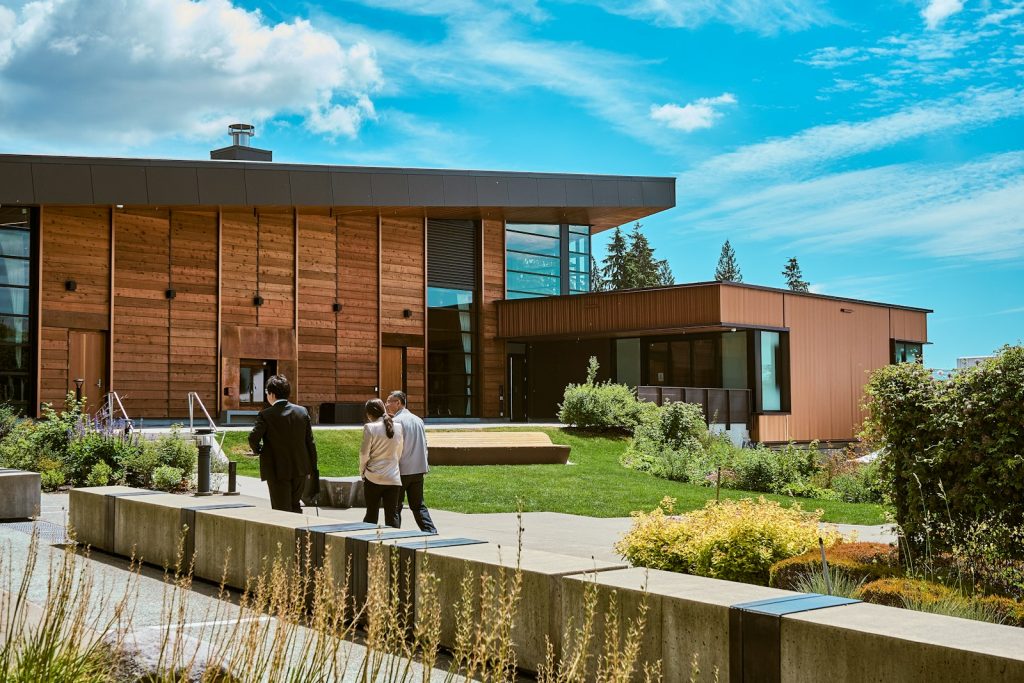Modern wood-clad community building with landscaped grounds, illustrative stock image.