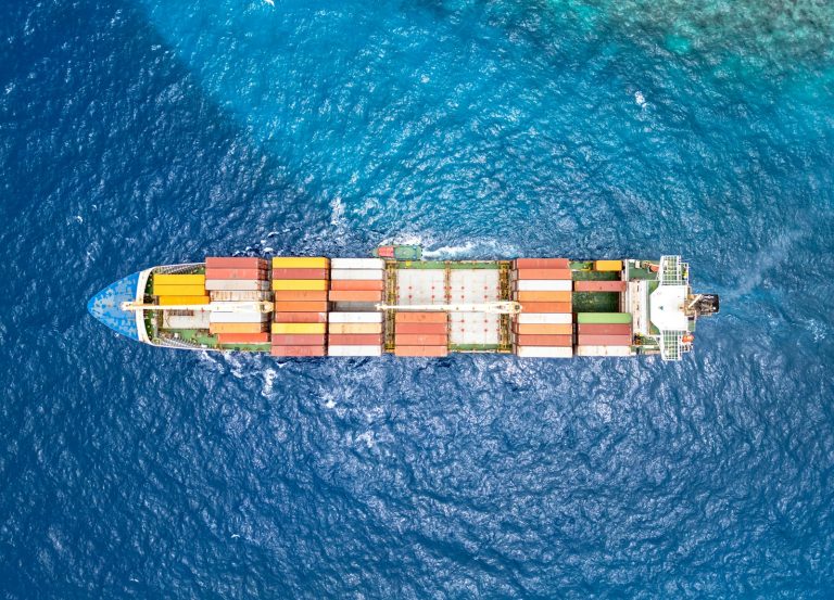 Container ship carrying freight across open water, illustrative stock image