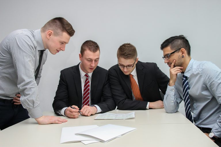 Four office workers reviewing a document together at a table