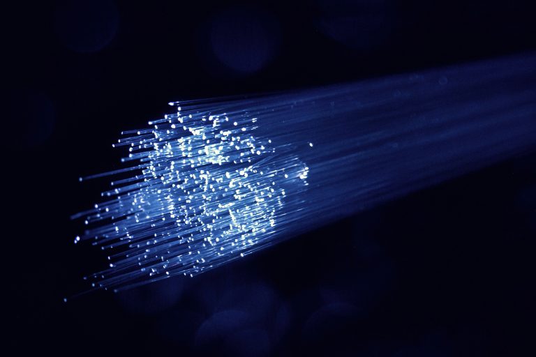 Bundle of glowing fibre-optic strands, illustrative image for telecommunications networks