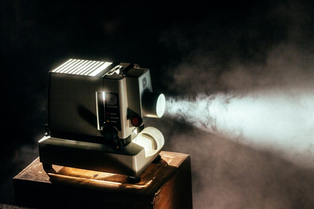 A lit film projector in a dark cinema setting
