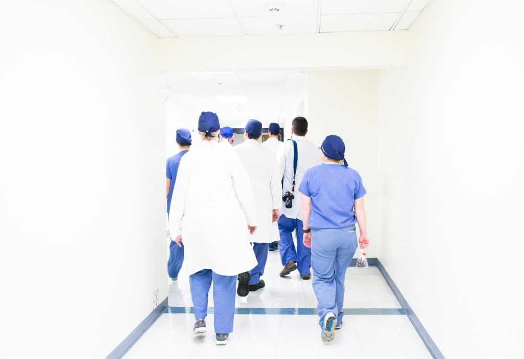 Doctors and nurses walking through a hospital corridor, illustrating health-worker licensing projects