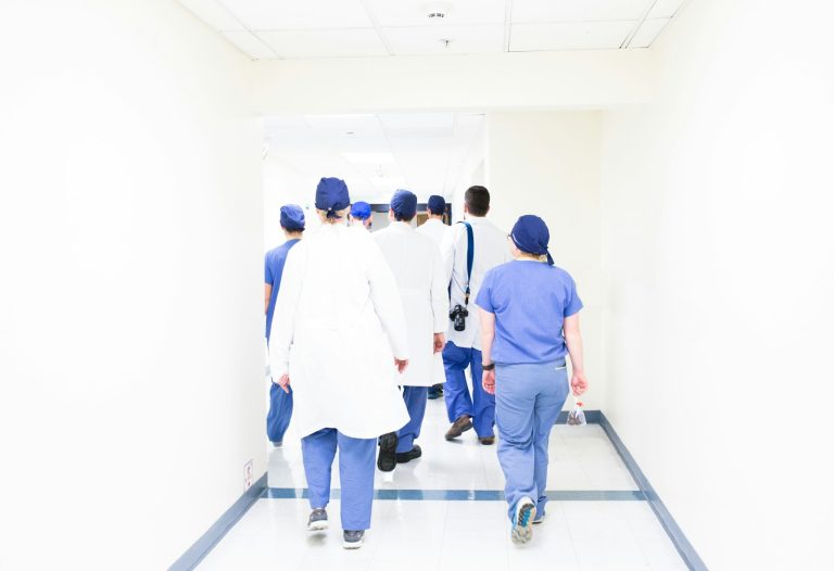 Doctors and nurses walking through a hospital corridor, illustrating health-worker licensing projects