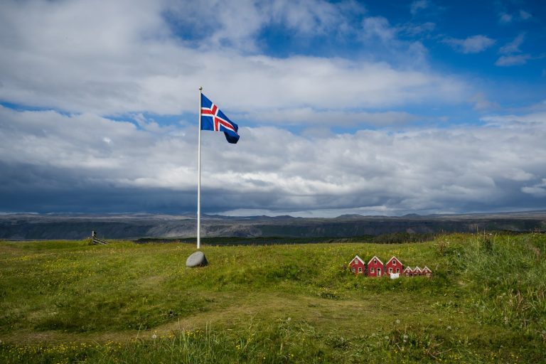 Icelandic flag flying on a pole in an open landscape