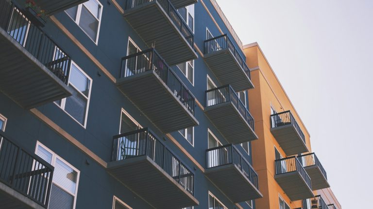 Blue and orange multi-unit apartment building with balconies