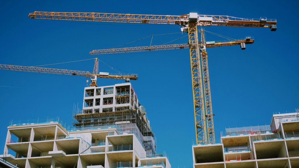 Apartment buildings under construction beneath several tower cranes