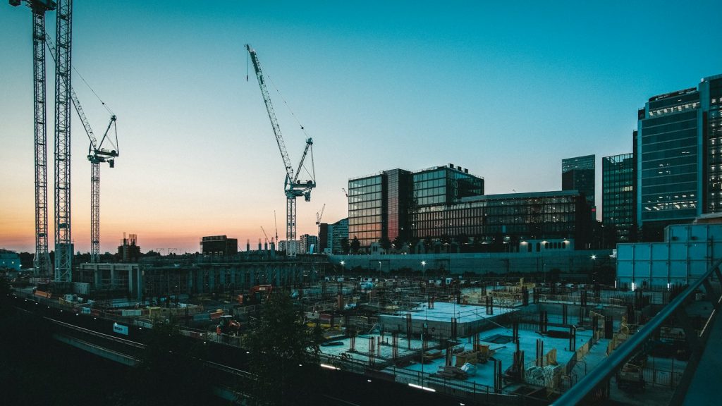 Large construction site with several cranes at dusk