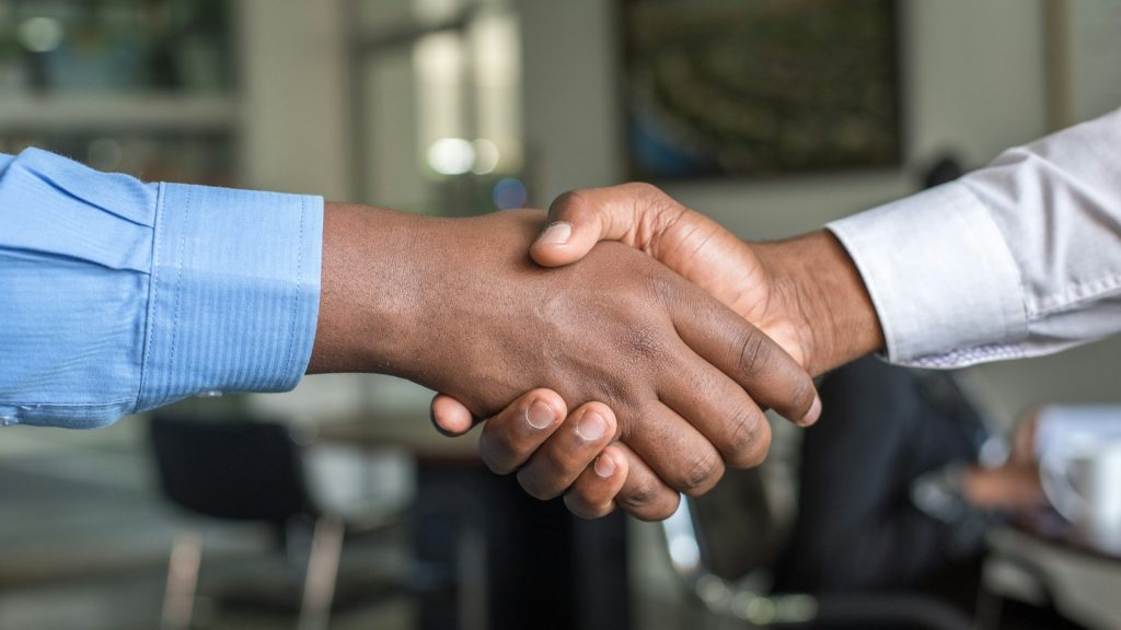 Close view of two people shaking hands at a meeting