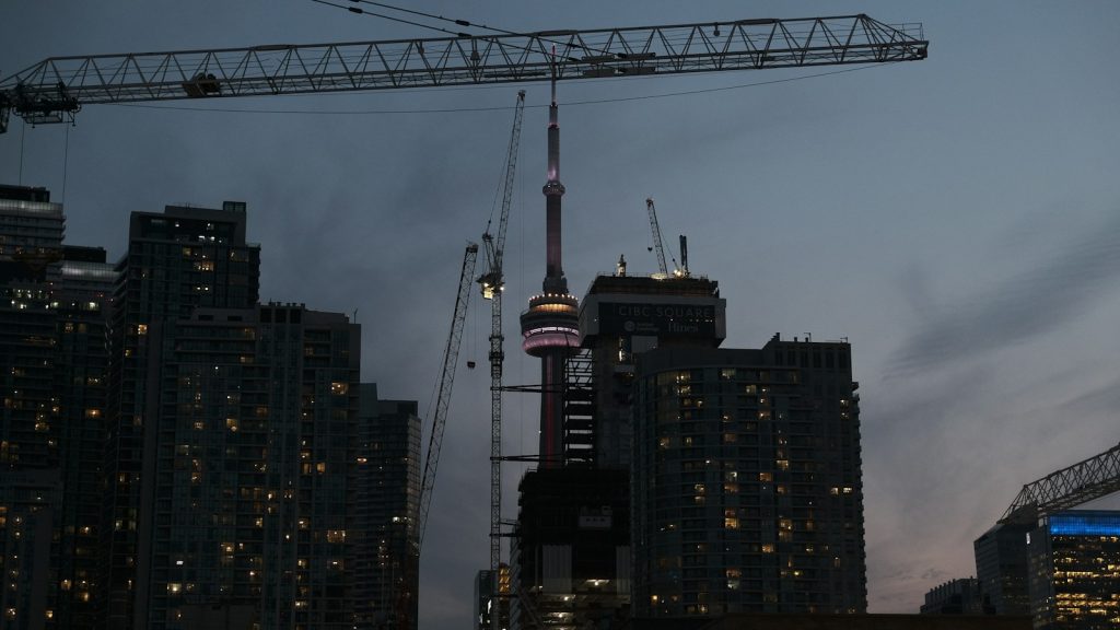 Construction cranes above residential buildings at dusk