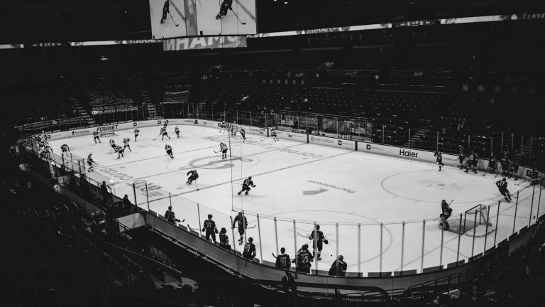 Black-and-white wide view of an ice hockey game in an arena