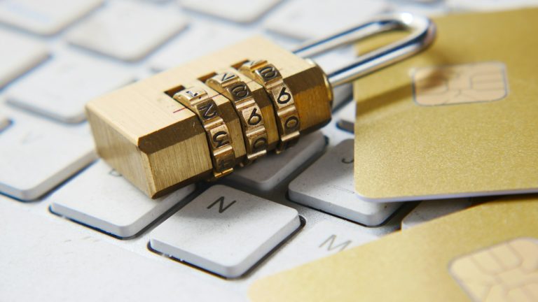 Gold combination padlock resting on a computer keyboard