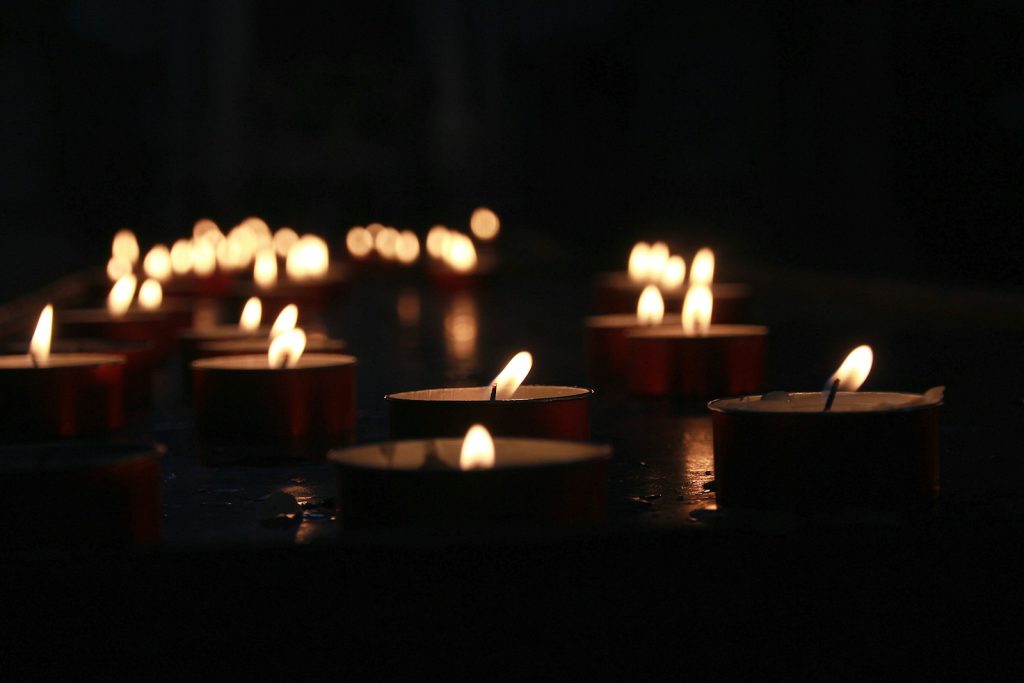 Lit candles in a dark setting, used as an illustration for a remembrance story