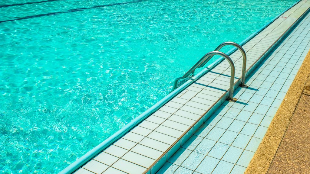 Outdoor swimming pool water and a metal ladder