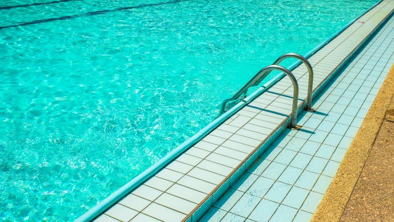 Outdoor swimming pool water and a metal ladder