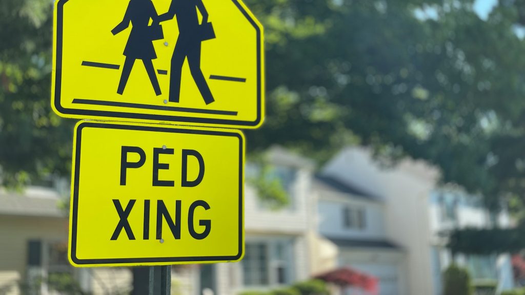 Yellow pedestrian crossing sign near a residential street