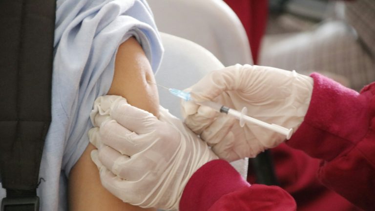 Healthcare worker administering a vaccine injection to a patient's upper arm