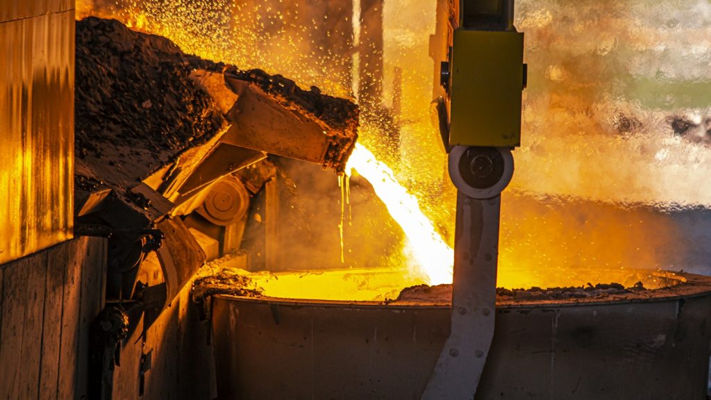 Molten metal being poured in an industrial steelmaking facility