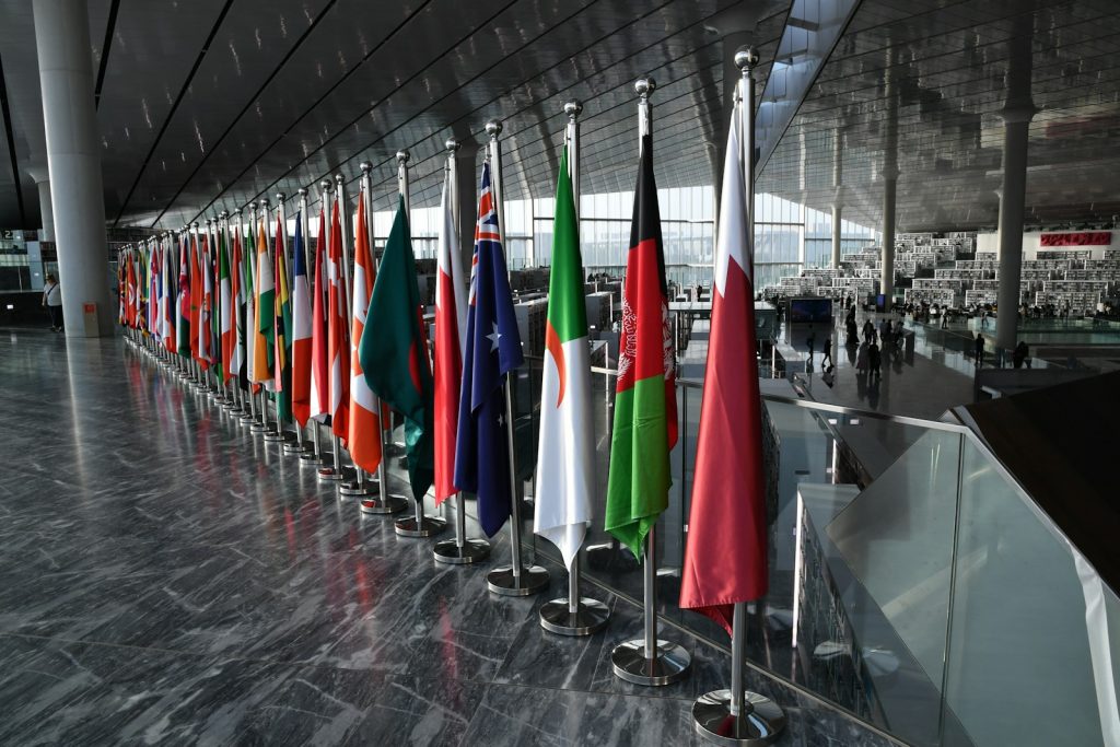 Row of national flags in a public building, illustrating international trade diplomacy