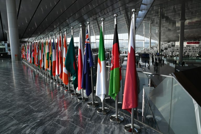 Row of national flags in a public building, illustrating international trade diplomacy