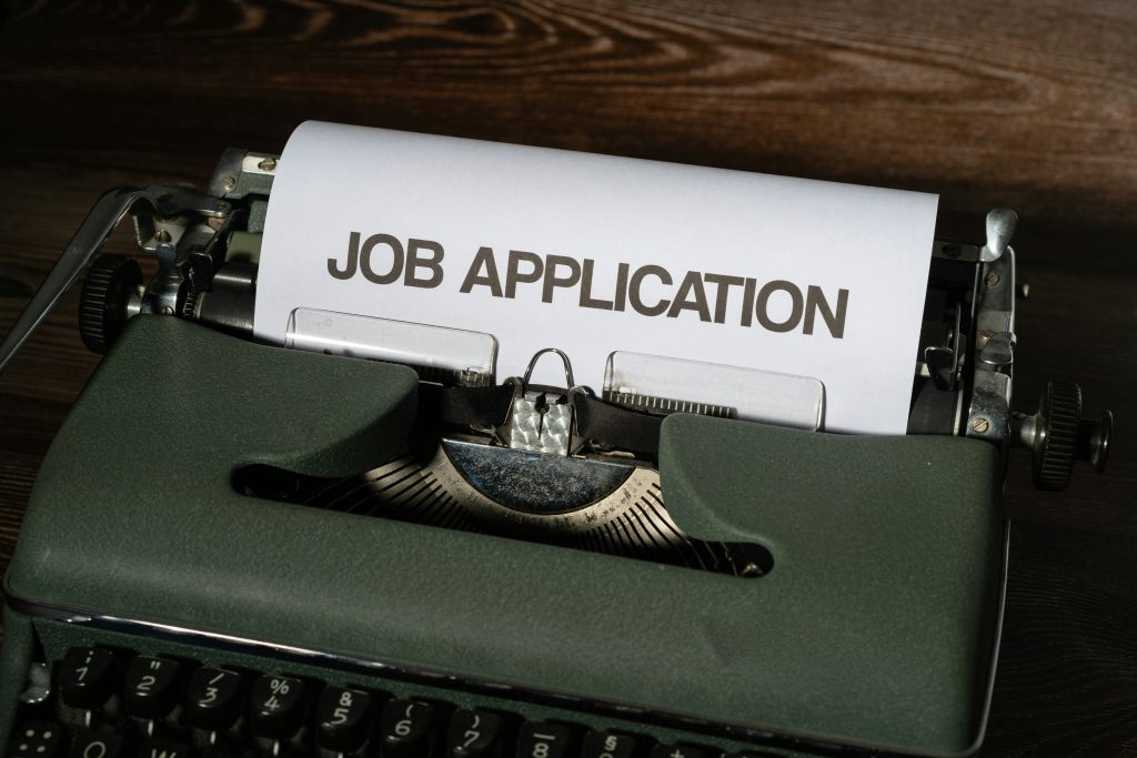 The words Job Application on paper in a typewriter