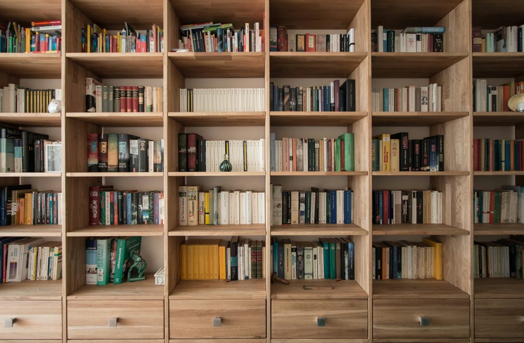 Warmly lit wooden library shelves filled with books