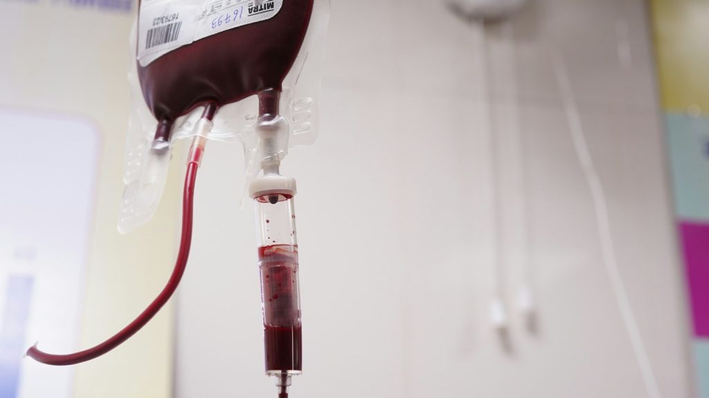 A medical blood bag and tubing in a clinical setting, illustrative image