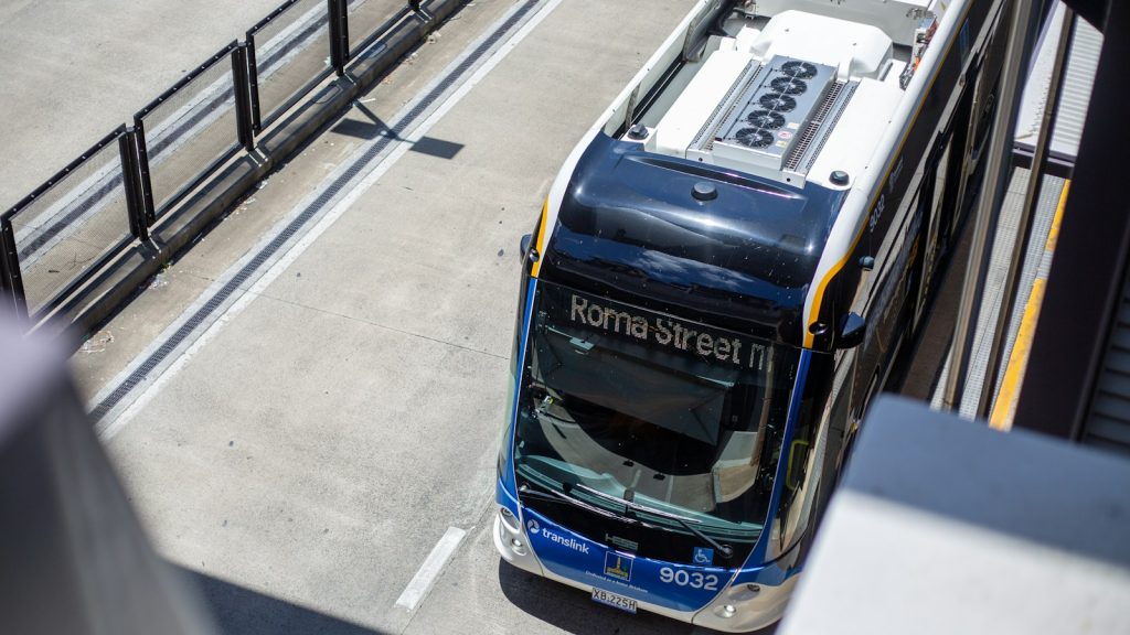 A modern passenger bus viewed from above at a station, illustrative image