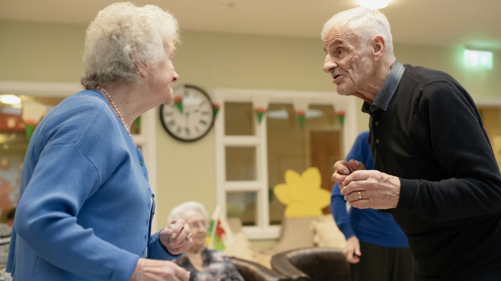 Two older adults talking at a community gathering