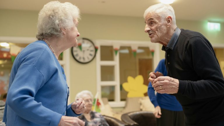 Two older adults talking at a community gathering