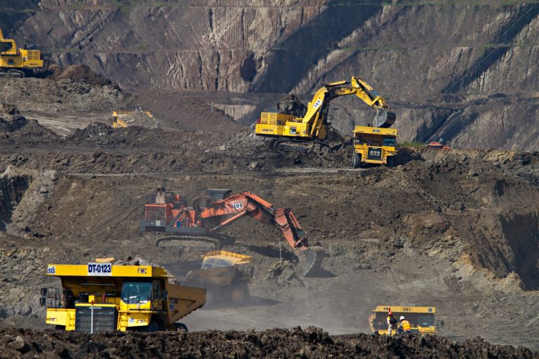 Excavator working in an open-pit mine, illustrating critical-mineral production