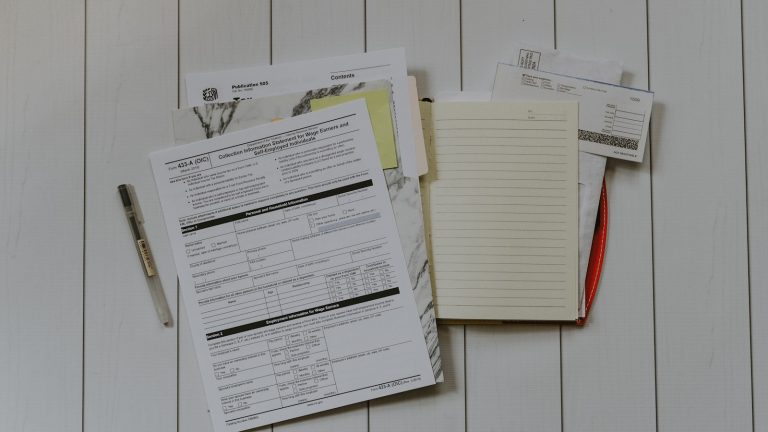 Paperwork, forms and a notebook on a desk, illustrating federal regulatory administration