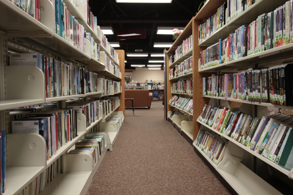 Empty aisle between bookshelves in a public library