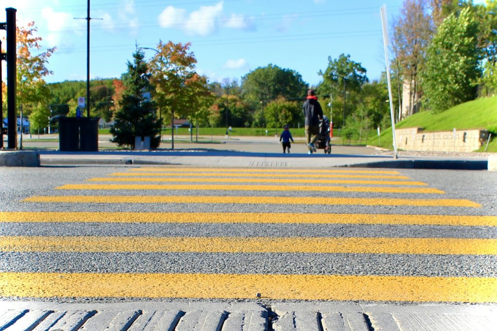 Yellow-striped pedestrian crosswalk in Gatineau, Quebec, illustrative stock image.
