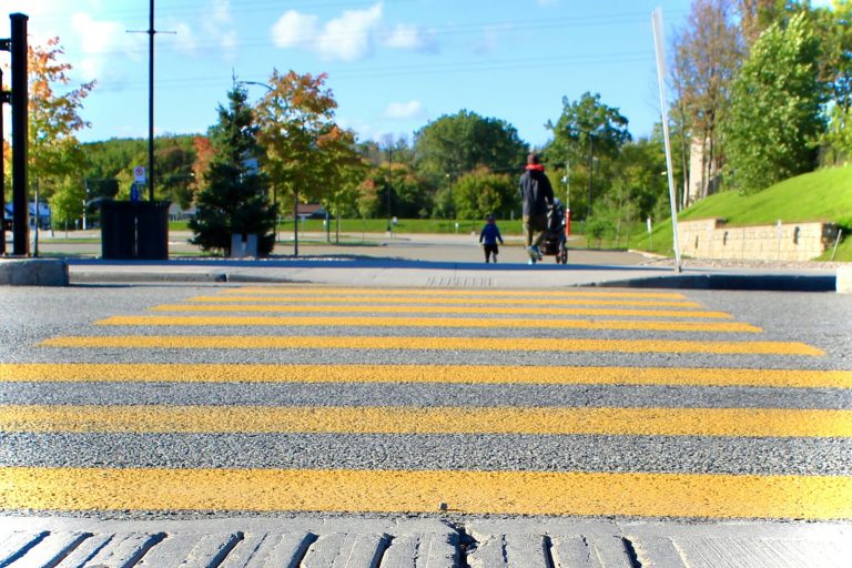 Yellow-striped pedestrian crosswalk in Gatineau, Quebec, illustrative stock image.