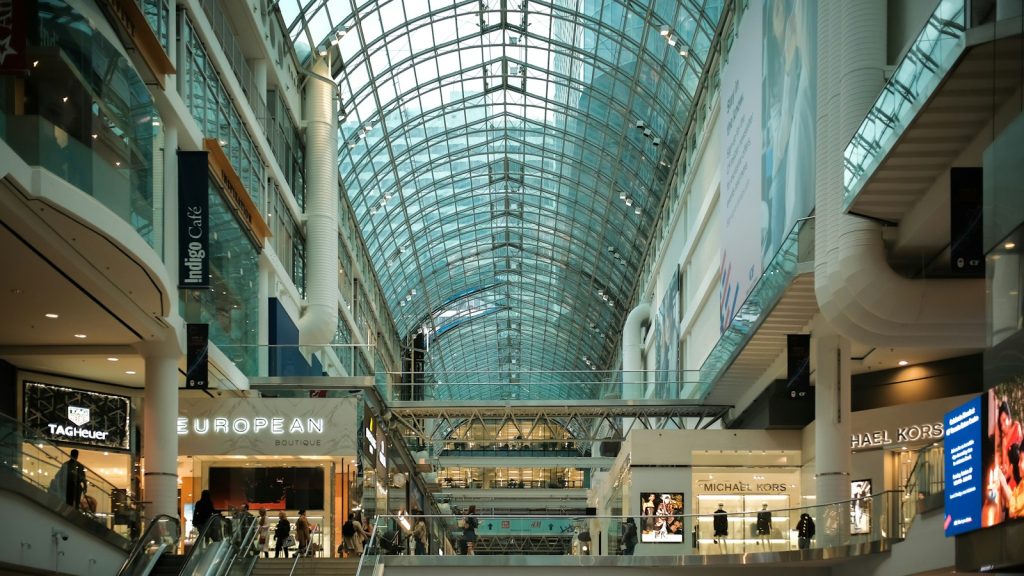 Interior of a multi-level shopping centre with stores and escalators