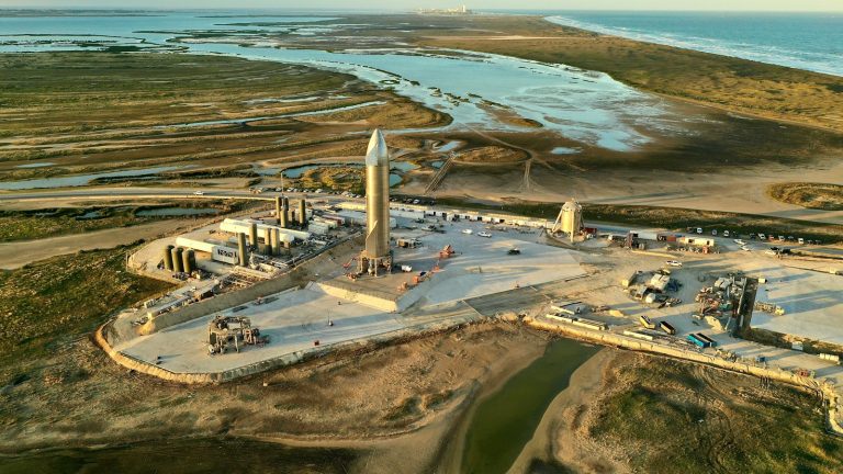 Aerial view of rockets and launch infrastructure at a coastal launch site