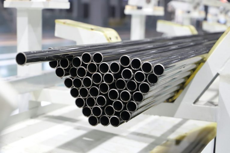 Stack of metal pipes on a factory line, illustrating oil-country tubular goods