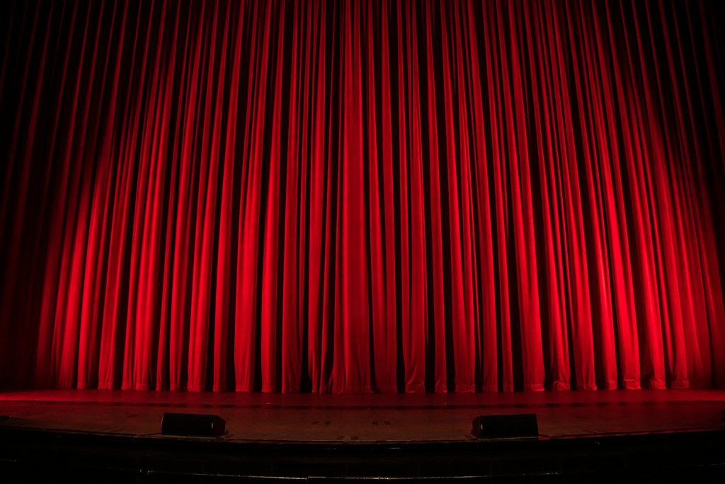 Closed red theatre curtain on a stage, illustrating the Hudson Village Theatre expansion