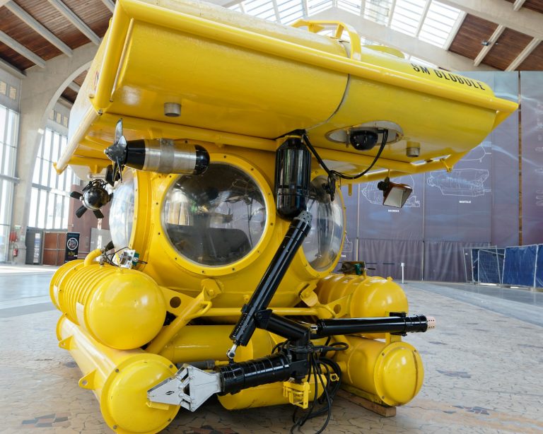 Yellow underwater vehicle with cameras and mechanical arms, illustrative stock image.