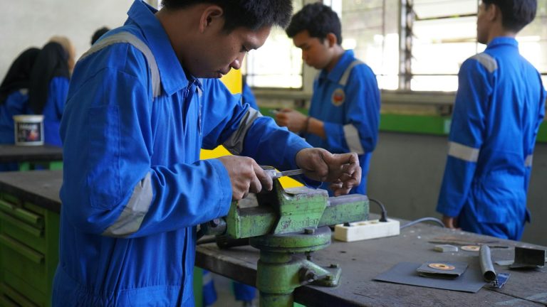 Trainees practising metalwork skills in a workshop