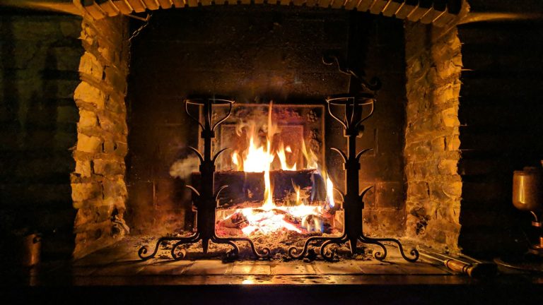 Wood fire burning in a stone fireplace, illustrating Beaconsfield’s solid-fuel appliance rules