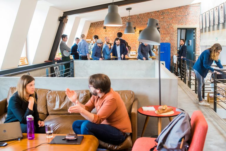 Young adults talking in a workplace, illustrative image for graduate employment statistics